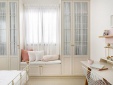 Встроенный шкаф с фасадами из МДФ белого цвета со стеклом и тумбой с сиденьем в спальню
